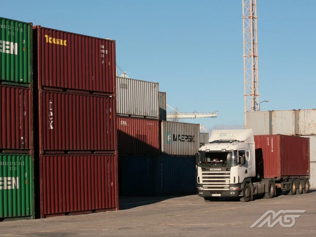 Containers in the storage yard and a lorry hauling a container out of the terminal